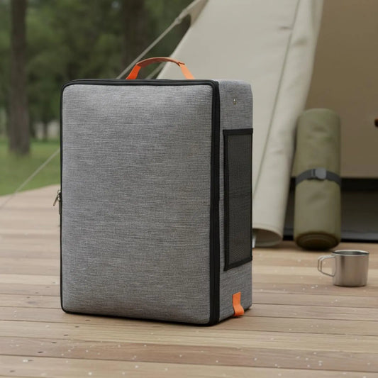 Gray cooler bag with orange accents on a wooden deck with a tent in the background
