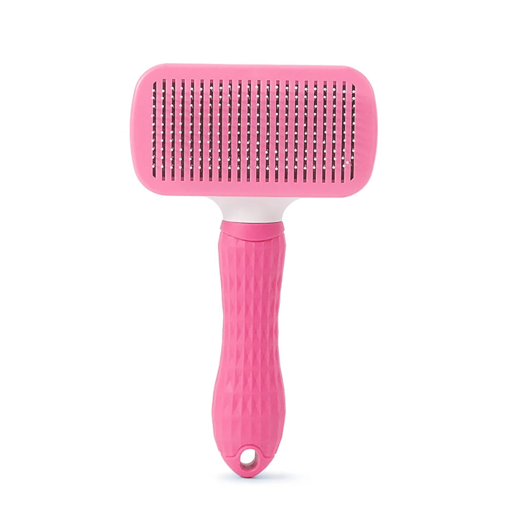 Pink pet grooming brush on a white background