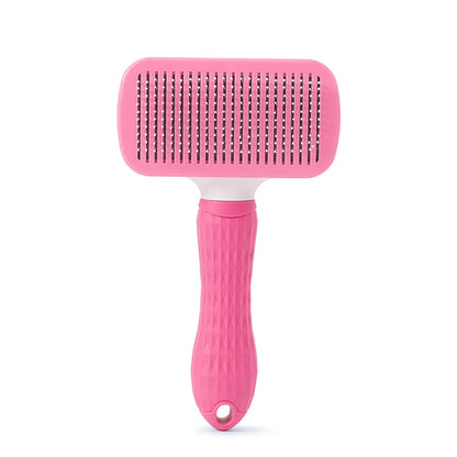 Pink pet grooming brush on a white background