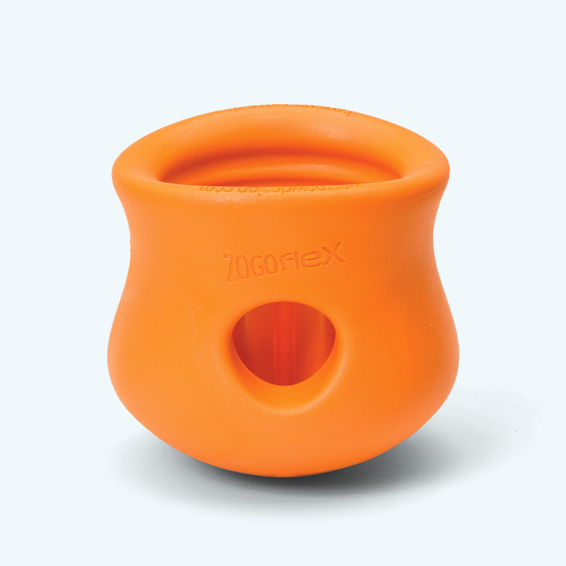 Orange dog toy with a central hole on a white background