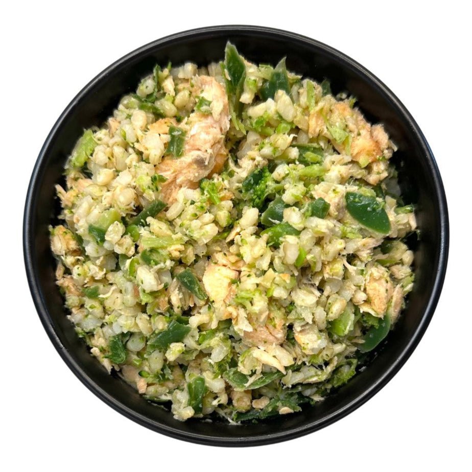 Black bowl filled with a green and brown salad on a white background