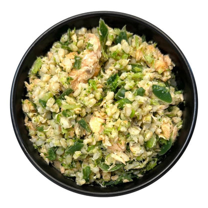 Black bowl filled with a green and brown salad on a white background