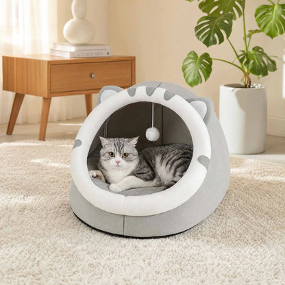 Cat lying in a gray pet bed with white interior in a home setting.