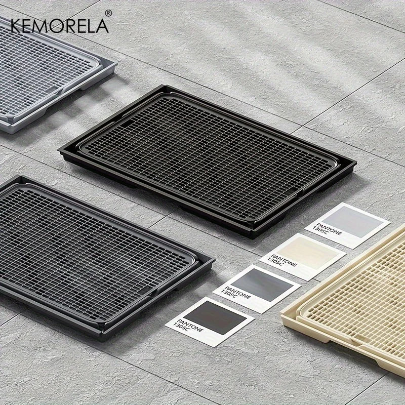Three black grates on a gray tiled floor with KEMORELA branding.
