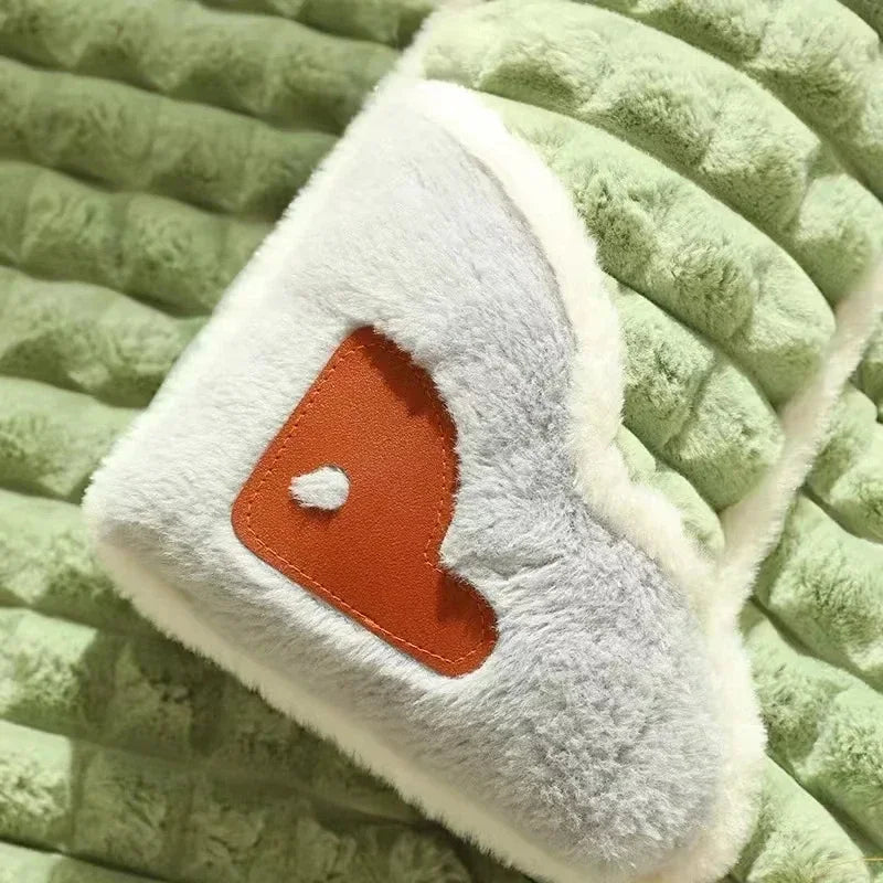 White plush toy with an orange heart on a green textured surface