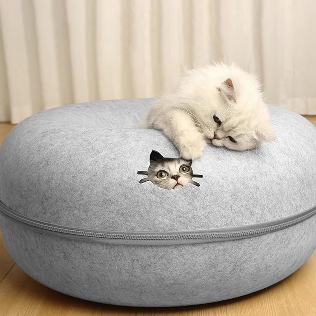 Gray cat-shaped ottoman with a small gray cat lying on top, against a neutral background.