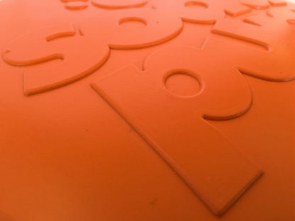 Close-up of an orange object with embossed text and shapes