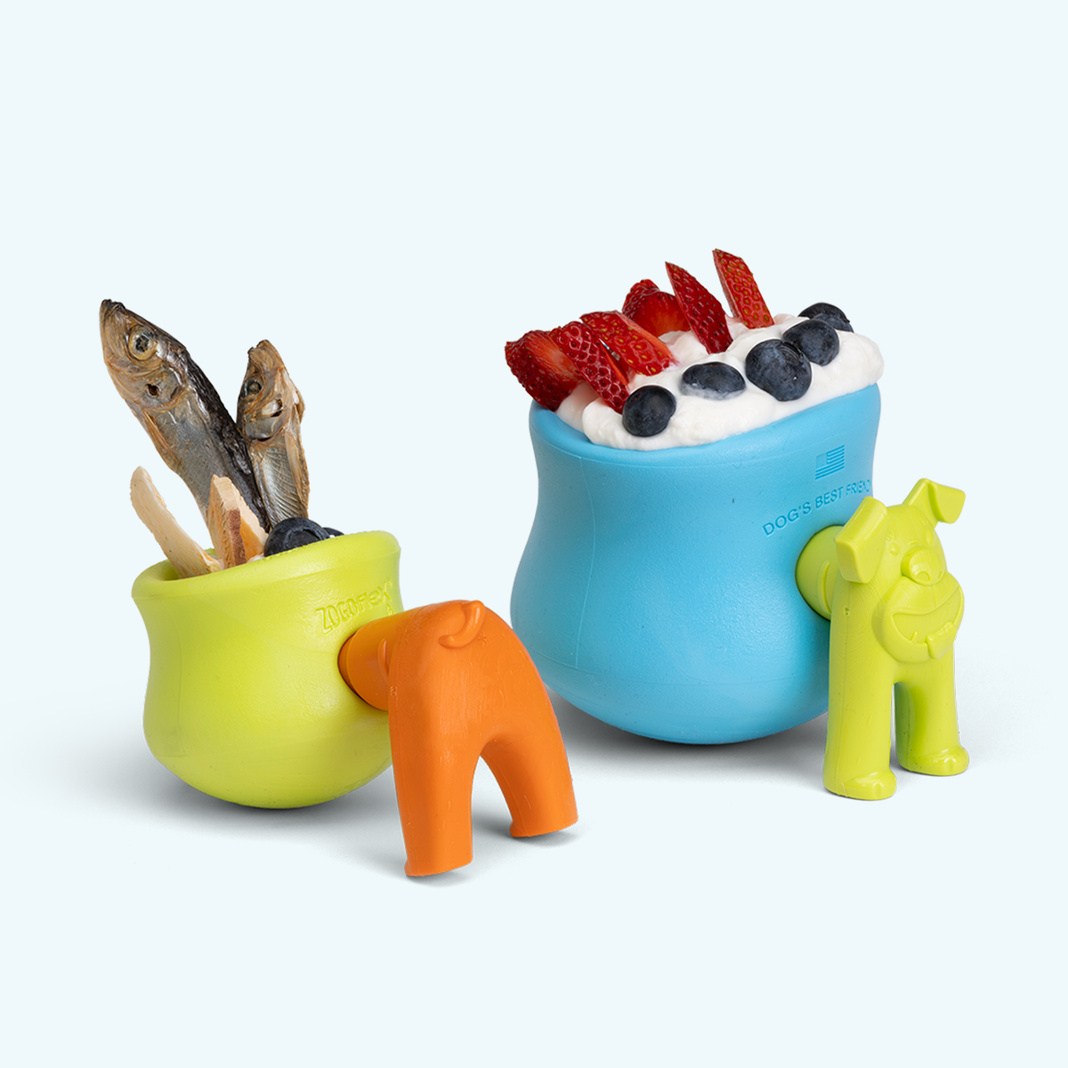 Colorful dog toys including a blue bowl with food, a green toy with fish, and a yellow toy.