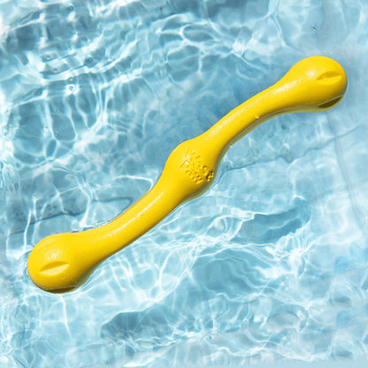 Yellow dog toy floating in clear blue water