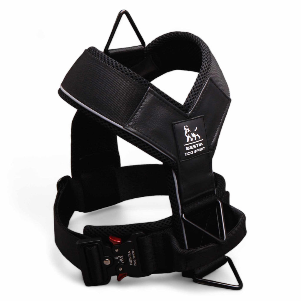 Black dog harness with visible brand logo on a white background
