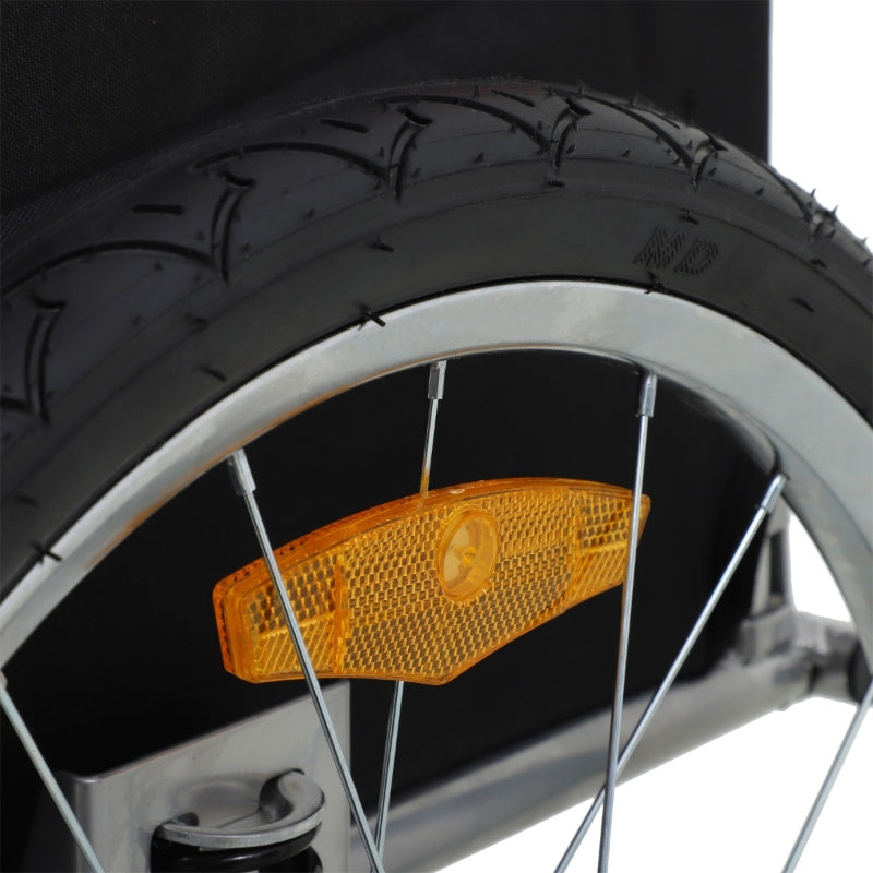 Close-up of a bicycle wheel with an orange reflector on a black background