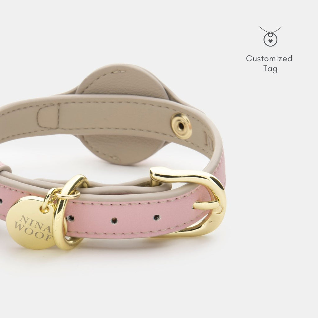 Pink and beige dog collar with gold hardware and a Nina Wu branded tag on a white background.