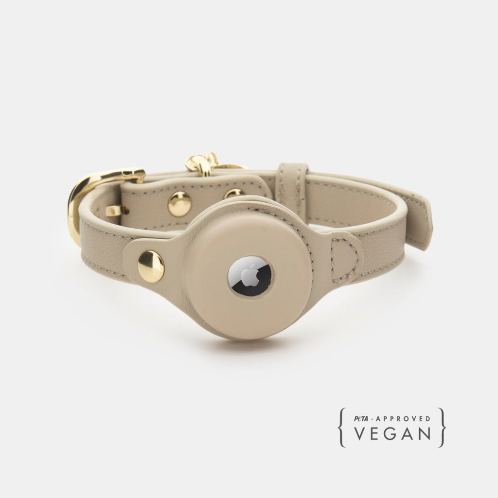 Beige leather collar with gold accents on a white background, featuring 'Vegan' label.