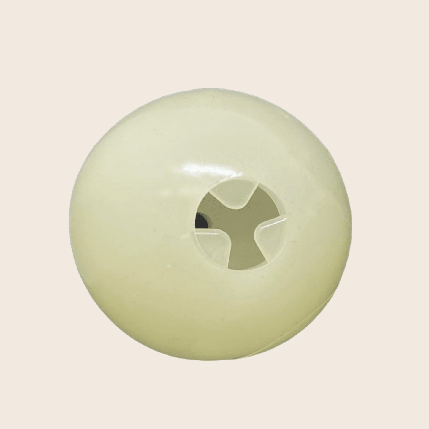 Round green object with a central cutout on a beige background