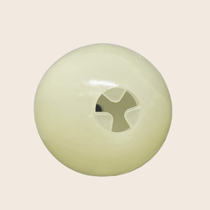 Round green object with a central cutout on a beige background