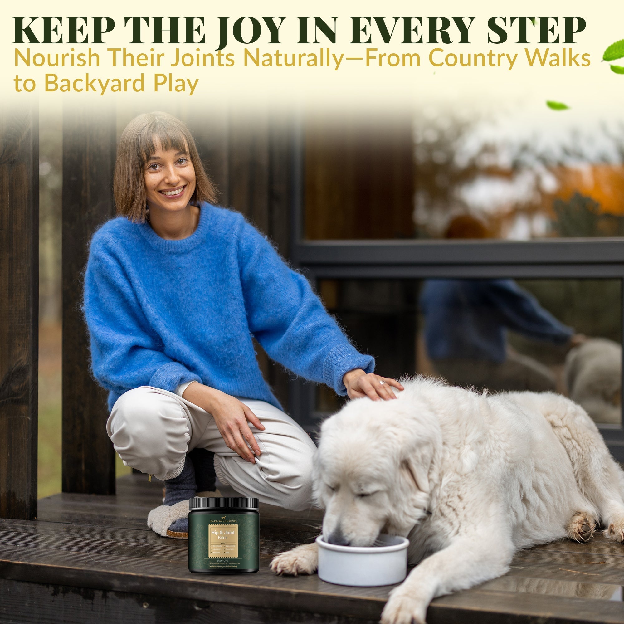 Woman in blue sweater petting a white dog by a candle on a wooden deck.