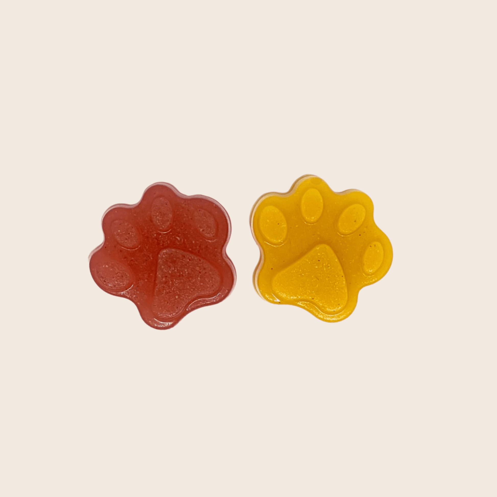 Two gummy bear shapes, one red and one yellow, on a beige background.