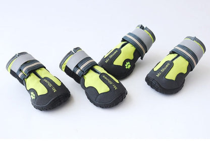 Four dog boots with green and black design on a white background