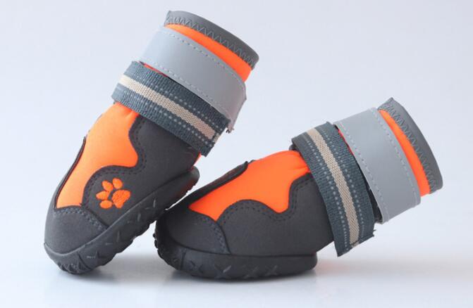 Pair of orange and gray dog boots on a light background