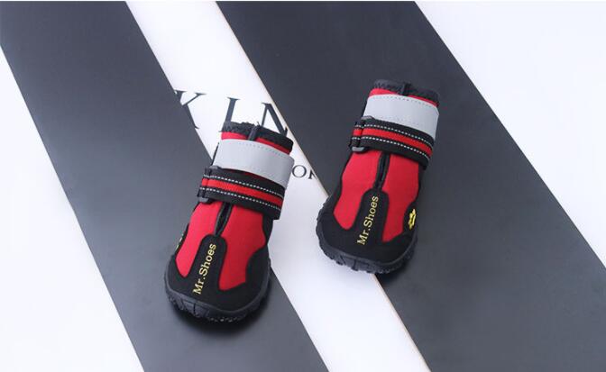 Red and black pet boots with gray straps on a black and white background