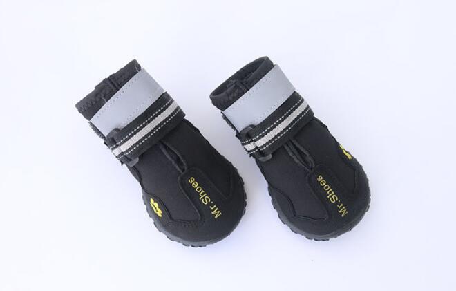 Pair of black dog boots with reflective straps on a white background