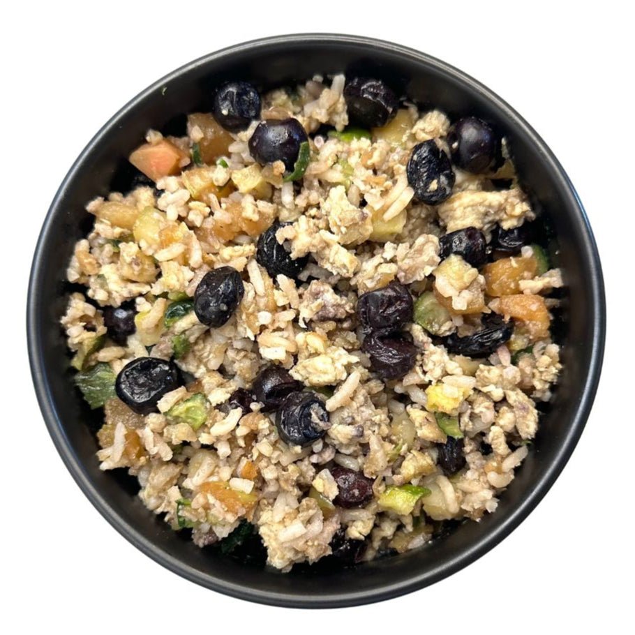 Black bowl filled with a rice dish containing dried fruits on a white background