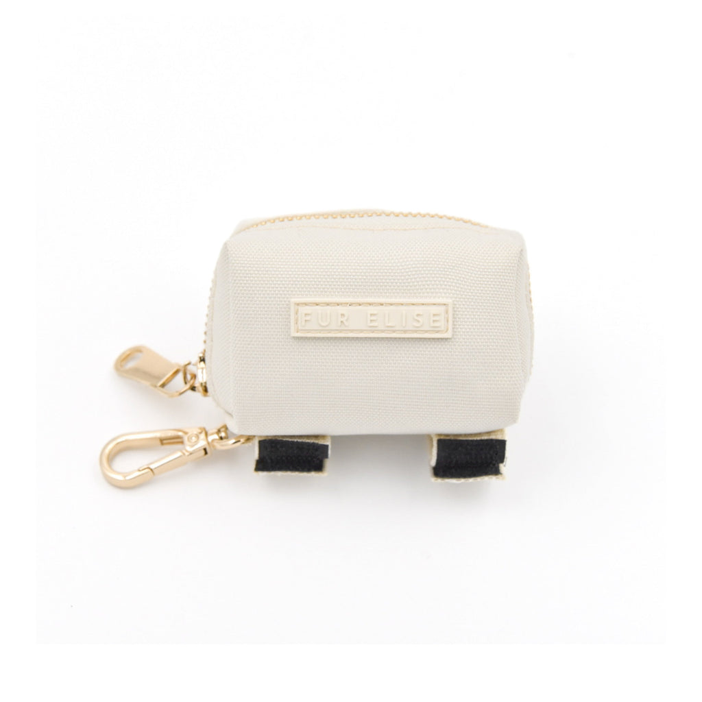 Small cream-colored pouch with gold zipper and black accents on a white background